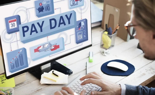 Écran d'ordinateur affichant « Pay Day », avec calendrier et pièces de monnaie, pour illustrer la gestion de la paie